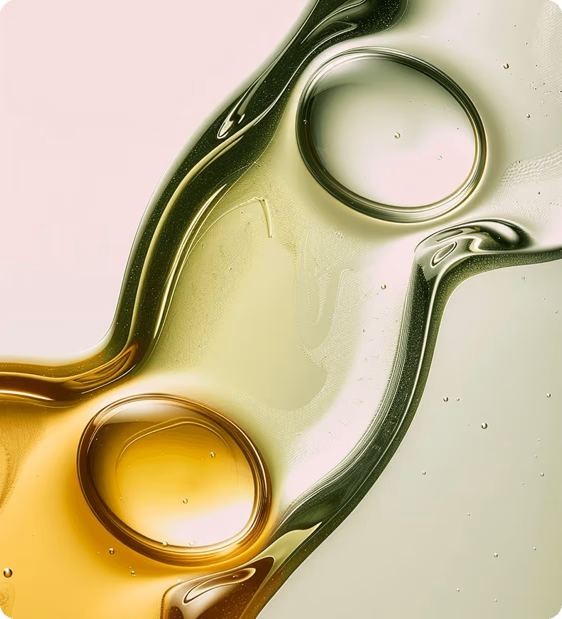 Close-up of clear yellow and green liquid drops merging on a light background.