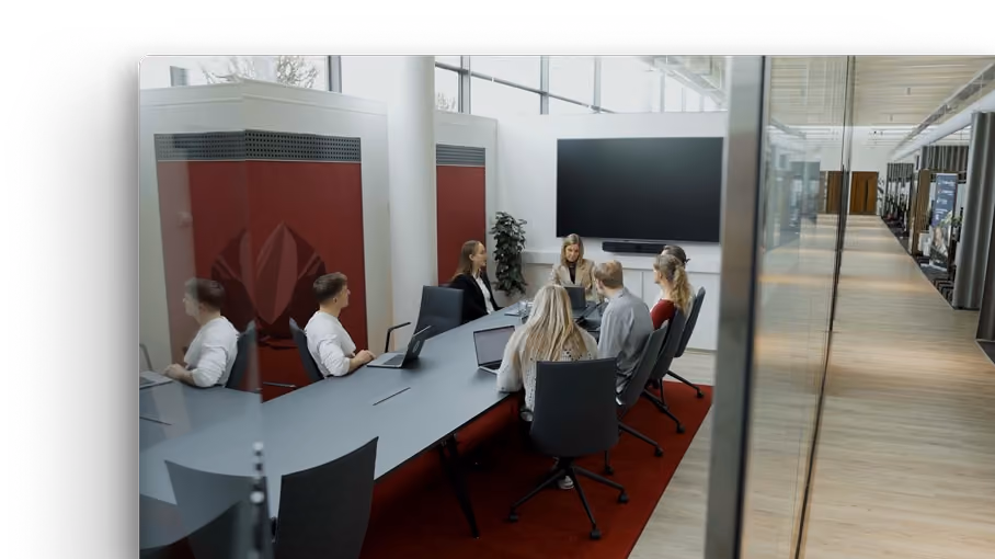 Komanda sapulcē modernā konferenču telpā.