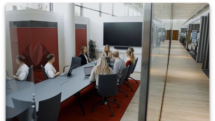 Komanda sapulcē modernā konferenču telpā.