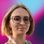 Sanita Kalniņa portreta foto ar brillēm uz rozā un gaiši zila fona.
