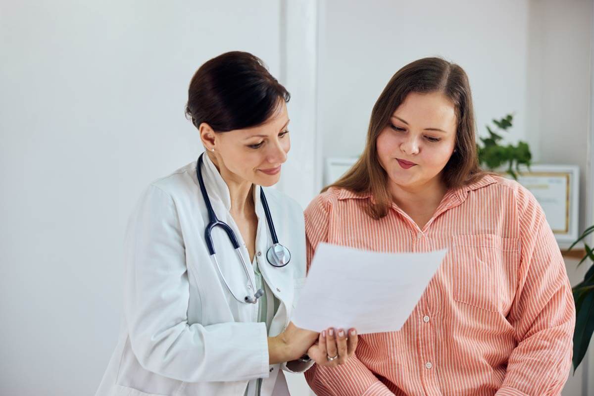 Frau mit Adipositas bespricht mit einer Ärztin die Nachsorge