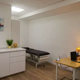 Cabinet d’ostéopathie avec bureau et table de soin à Boulogne-Billancourt