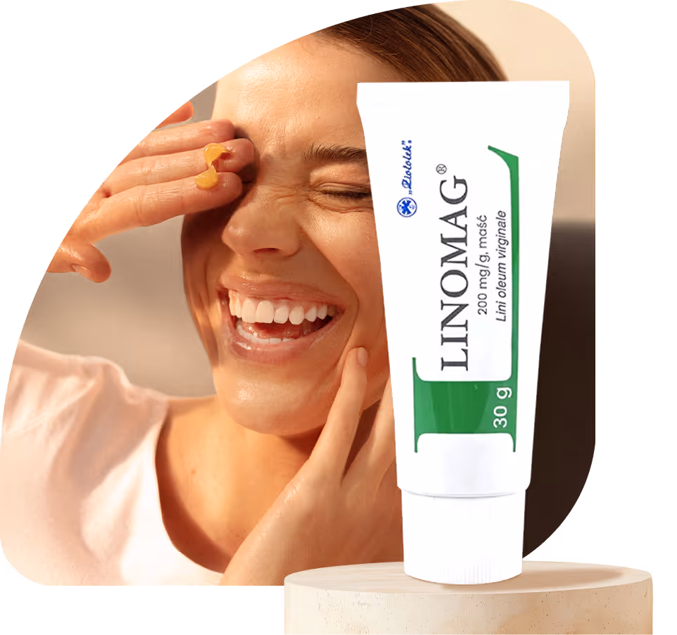 Kobieta uśmiecha się, dotykając twarzy z maścią Linomag na palcu.