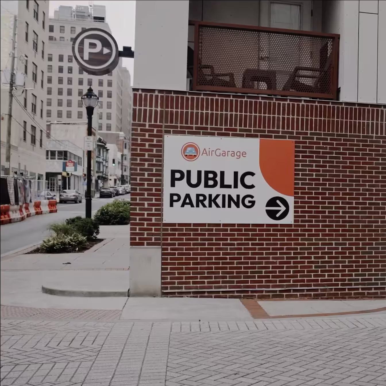 AirGarage public parking sign with directional arrow mounted on a brick building in a city street