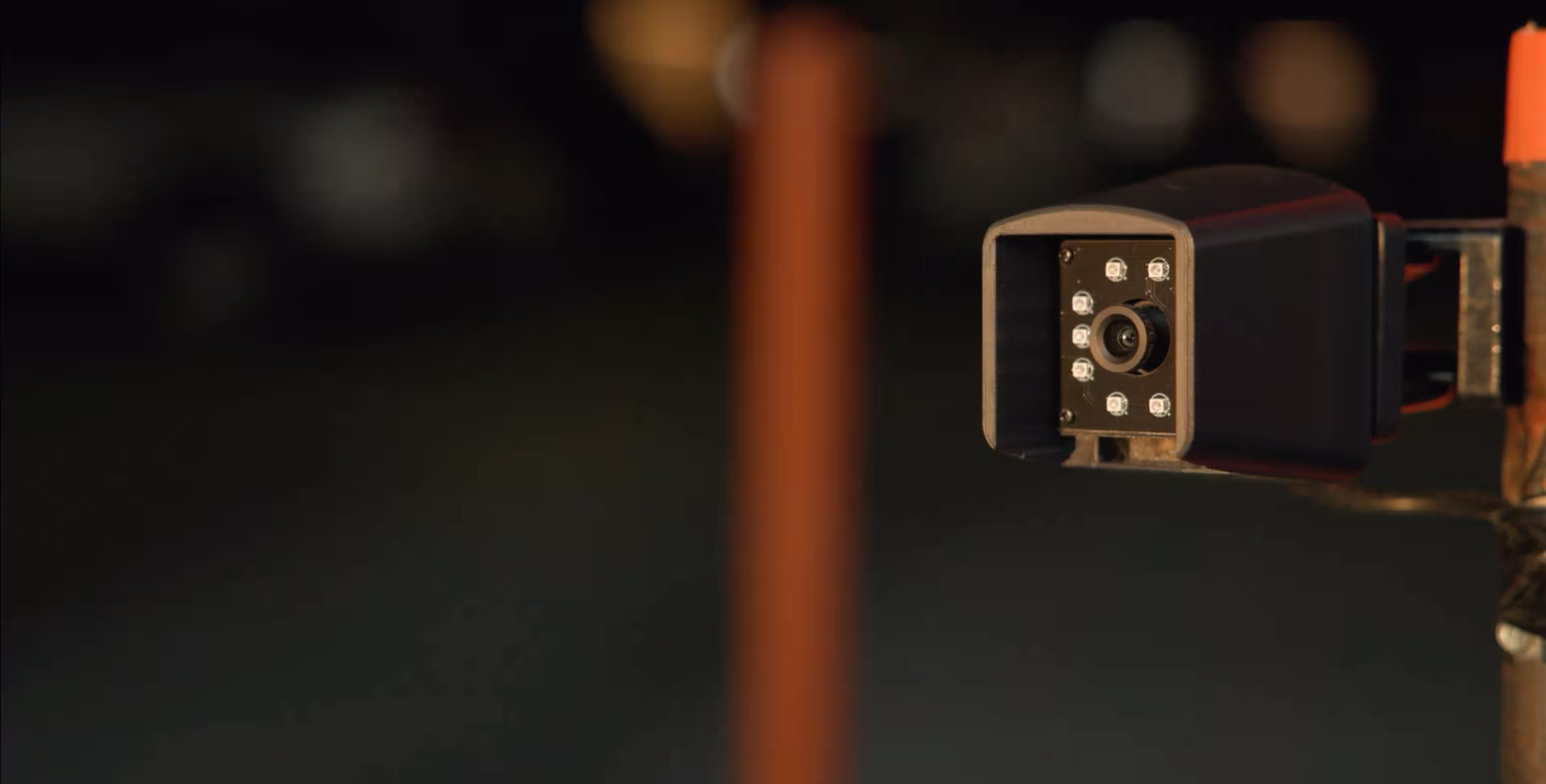 AirGarage license plate recognition camera mounted on a pole in a parking lot at night