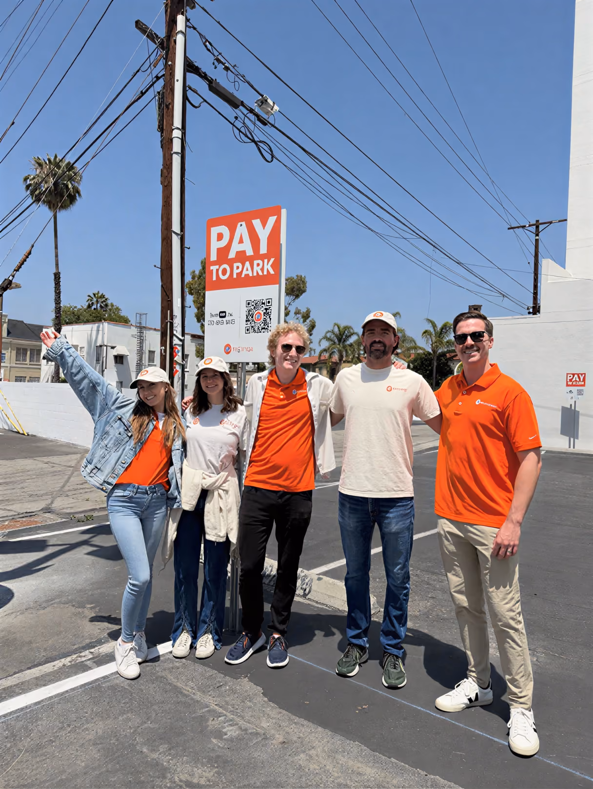 AirGarage team members posing together next to a Pay to Park sign in a parking lot