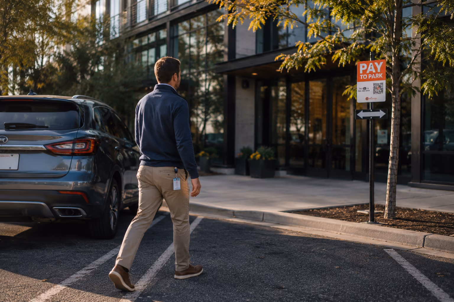 Man wearing a badge walking into an office after parking in a monthly parking lot.
