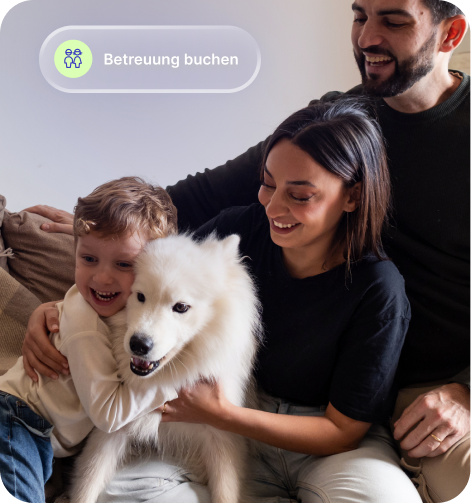 Glückliche Familie mit Kind und weißem Hund sitzt zusammen auf einem Sofa.