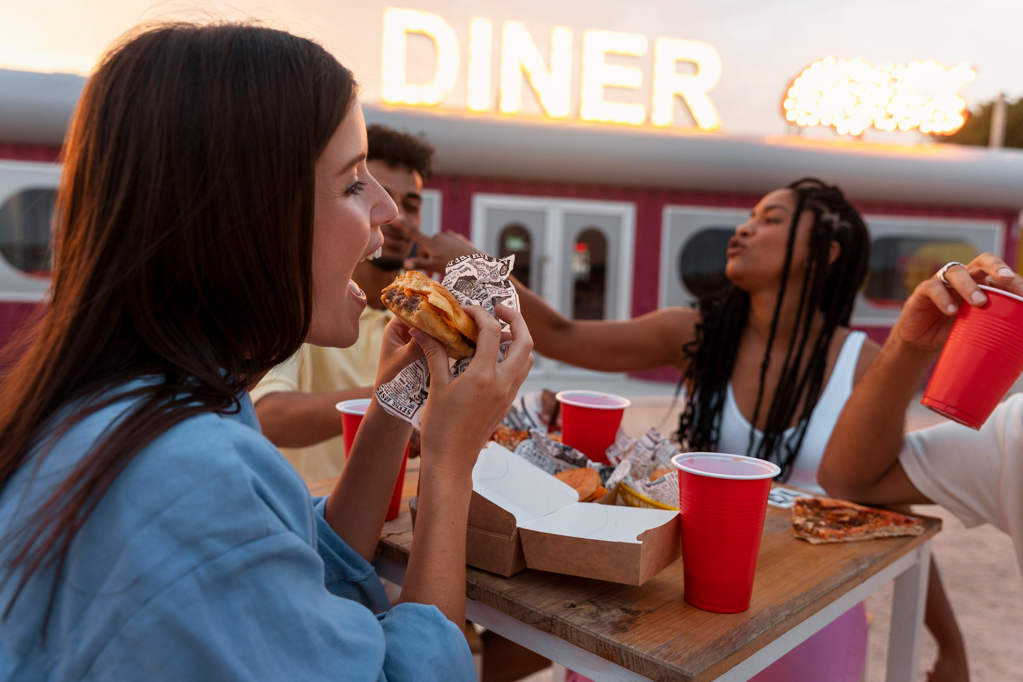 A group of people sitting at a table eating food.