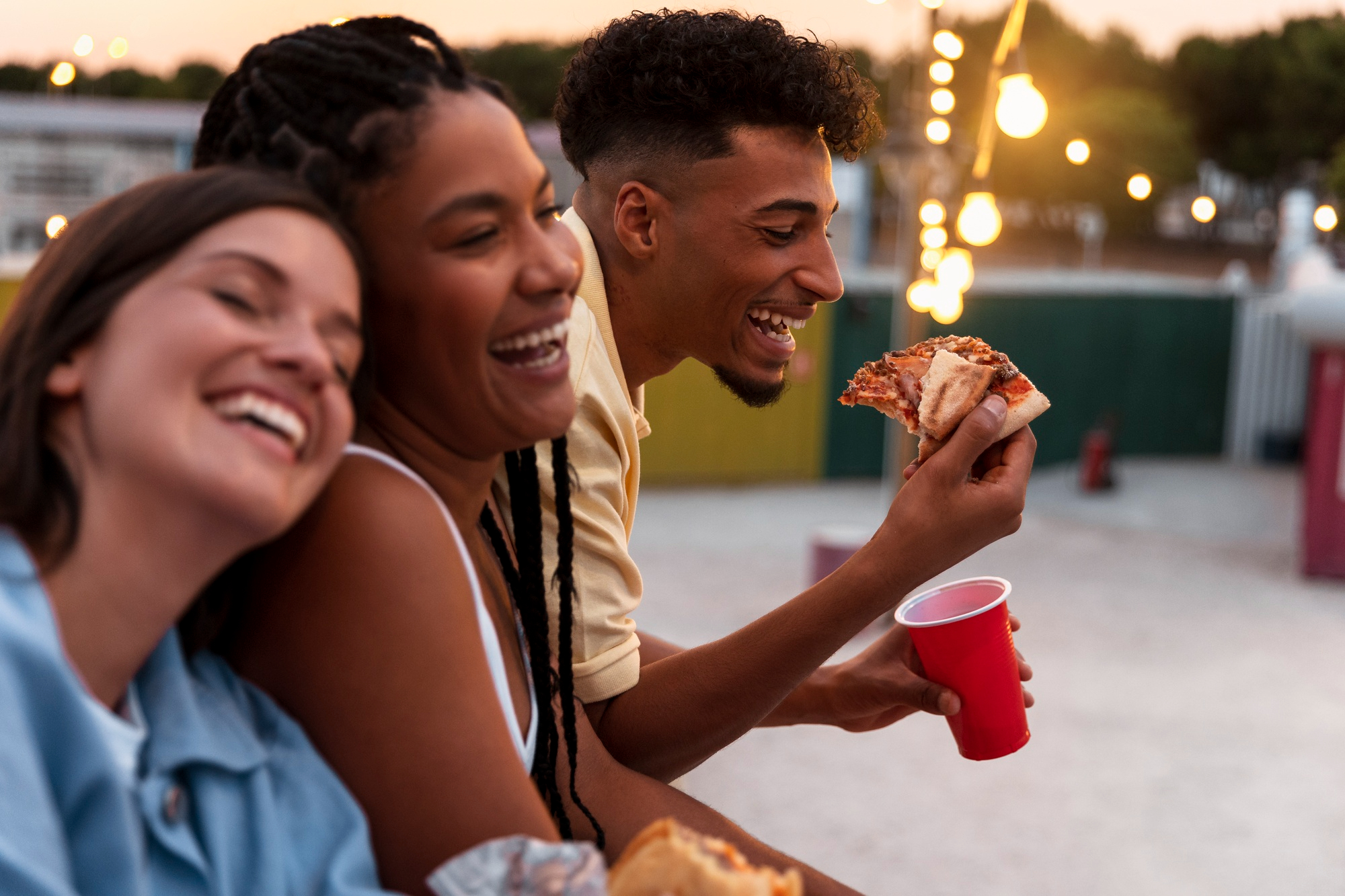 A group of people eating pizza and drinking soda.