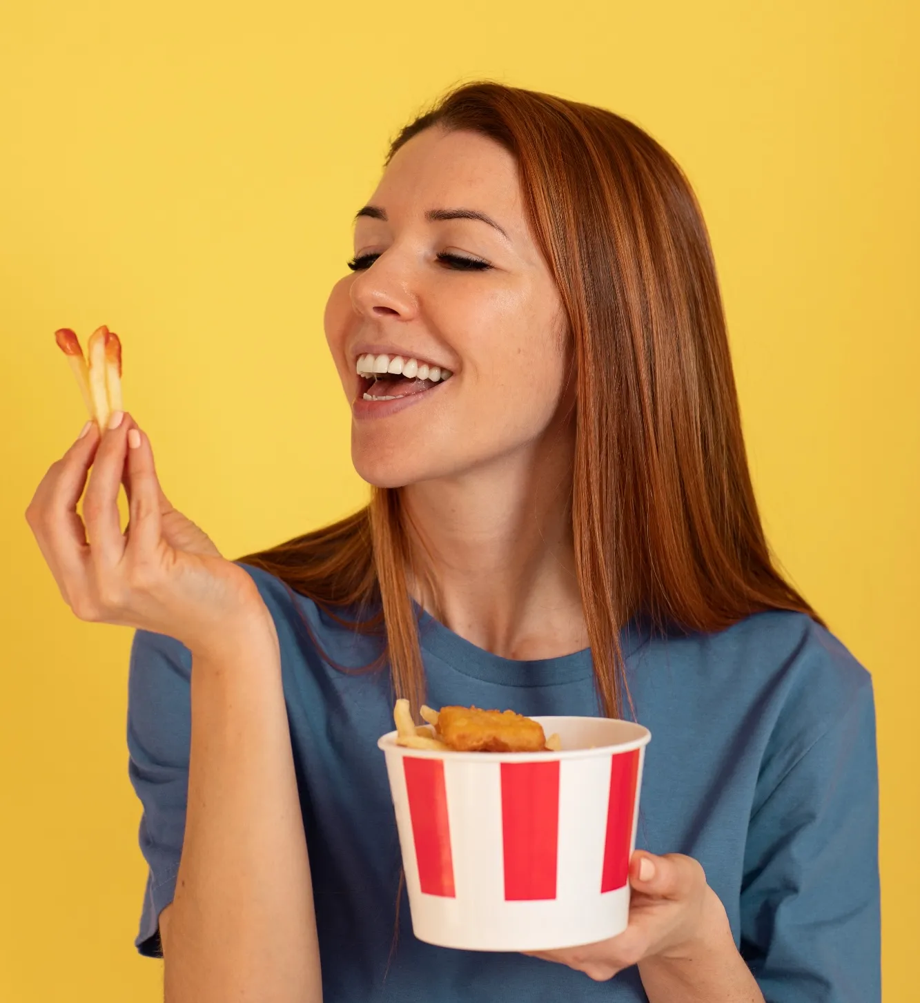 A woman holding a bowl of food and smiling.