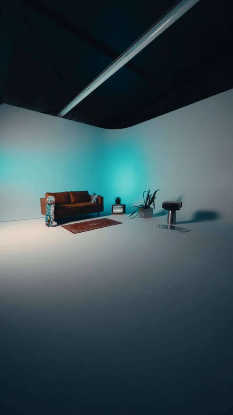 Setdesign im Hochformat mit türkisem Licht, Sofa, Röhrenfernseher und Pflanzen