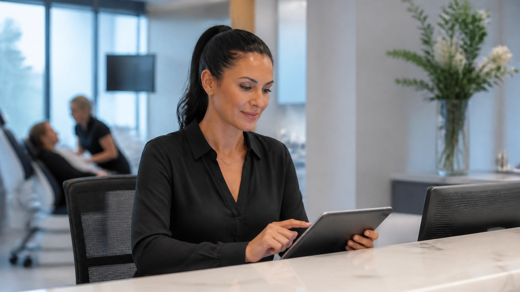 Dental practice manager completing a simple application on a computer in a modern office