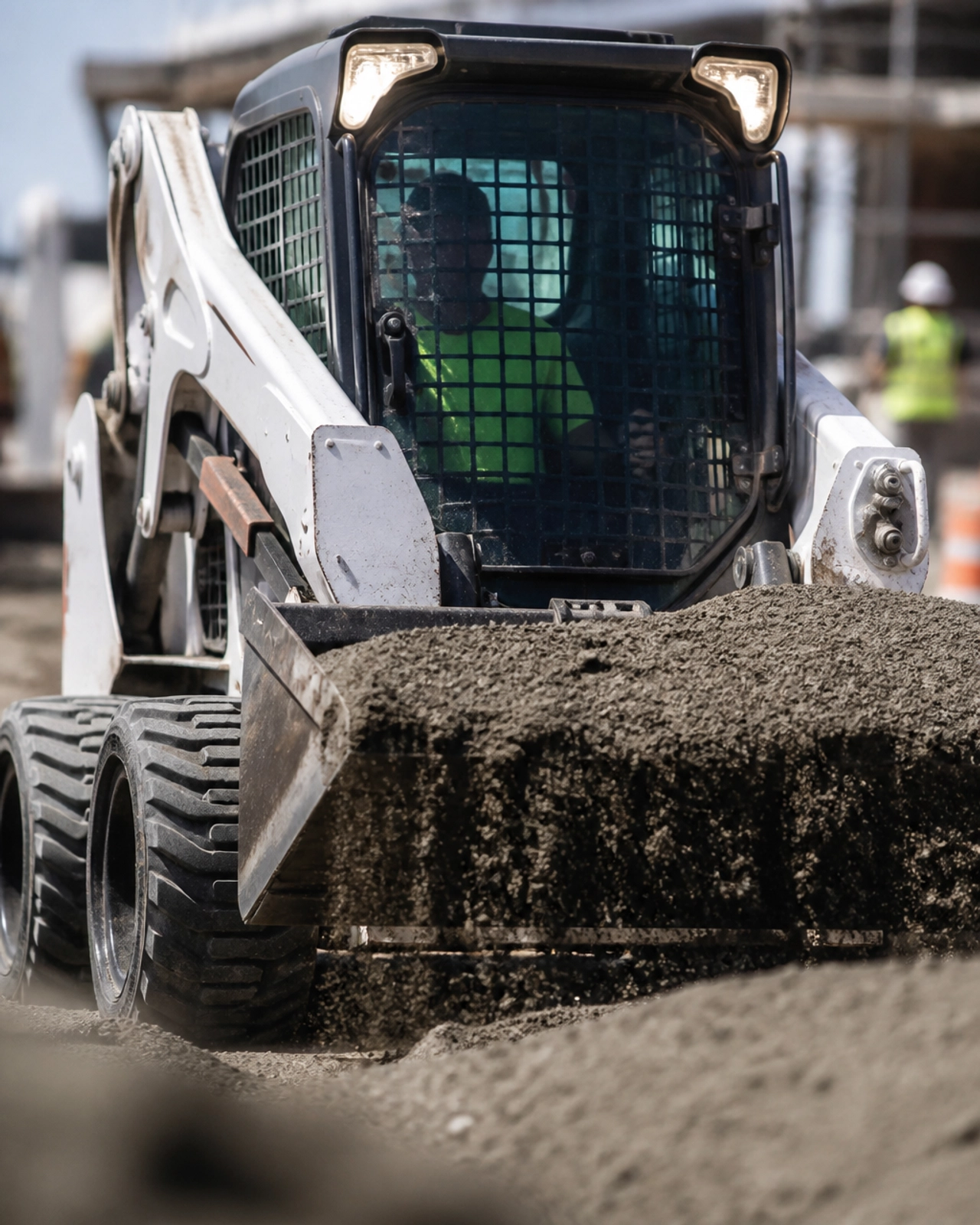 Close-up of specialized construction equipment, a skid steer loader, working on a job site