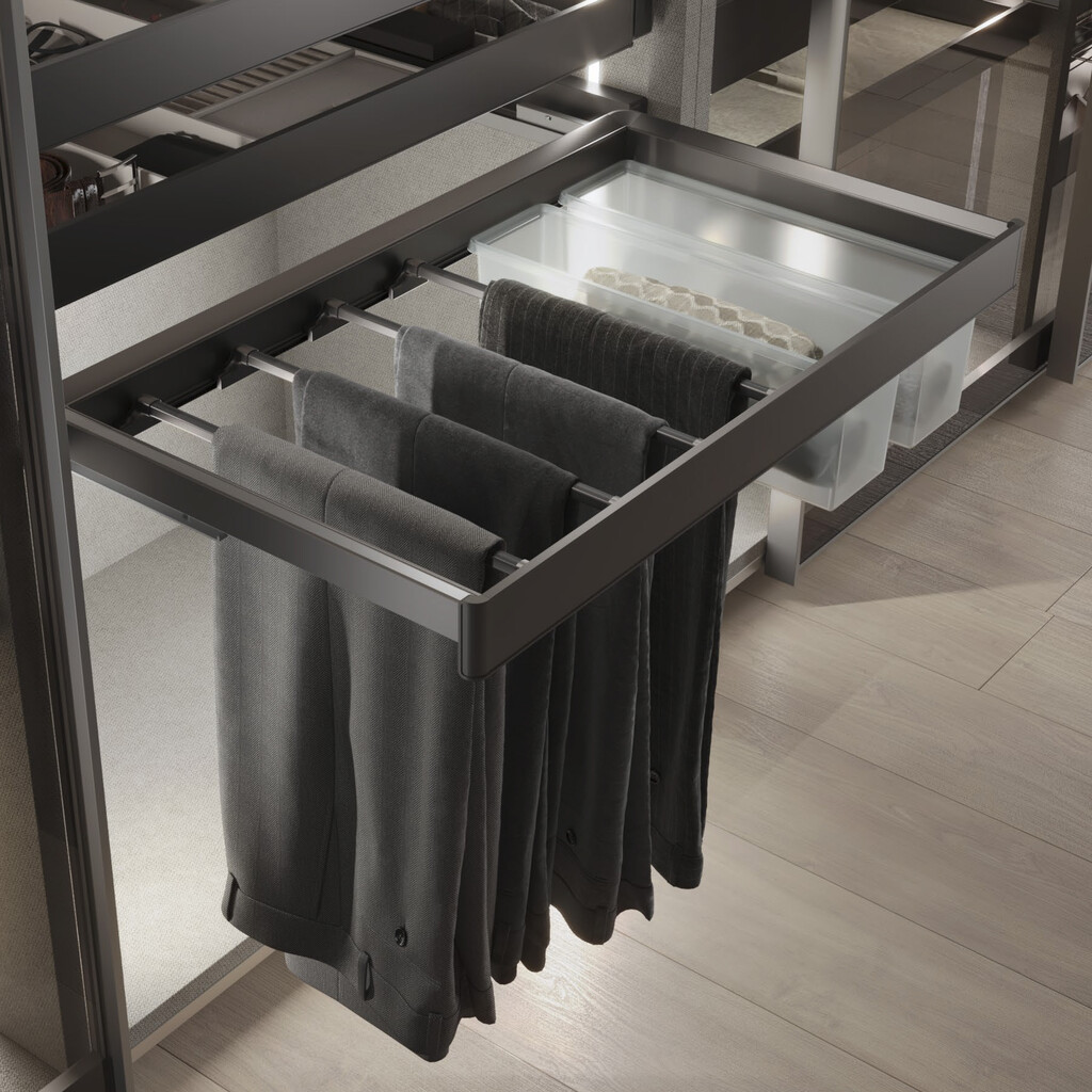 Pull-out closet organizer with multiple horizontal rods holding dark pants and clear storage bins.