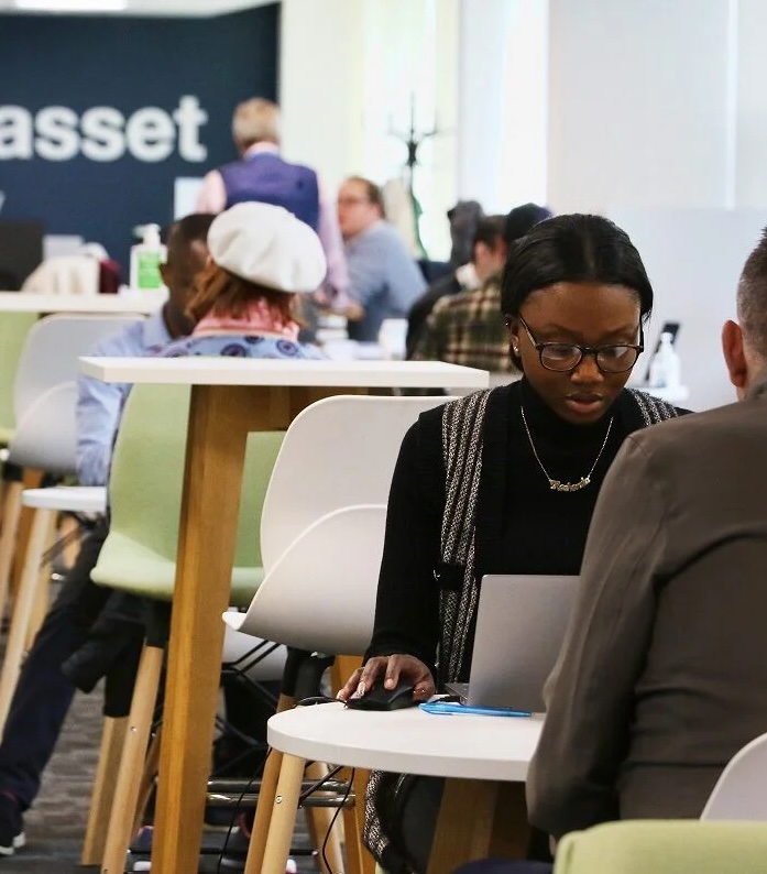 Woman speaking with a Fedcap UK adviser during a community support session.