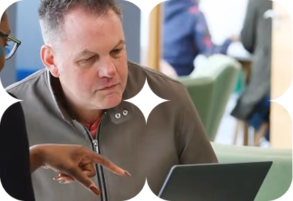 Colleagues reviewing information on a laptop during an employment support session.