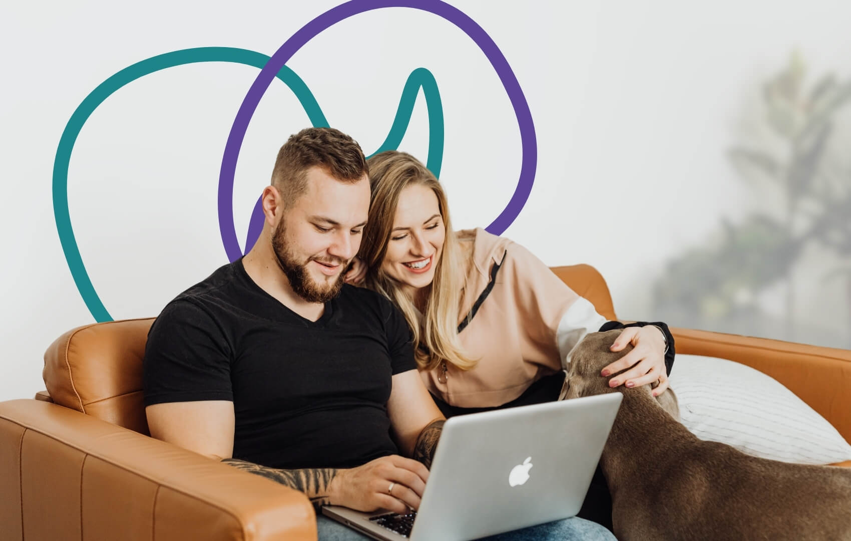 A couple sit close together on a sofa, sharing a laptop and smiling. 