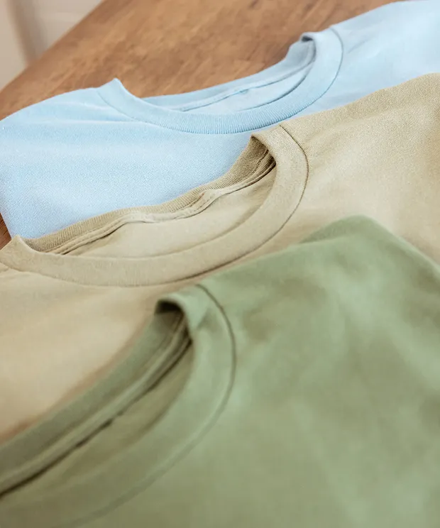 Neutral t-shirts flat lay on brown table