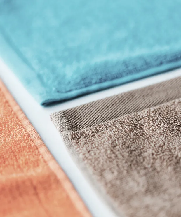 Three beach towels on a flat background