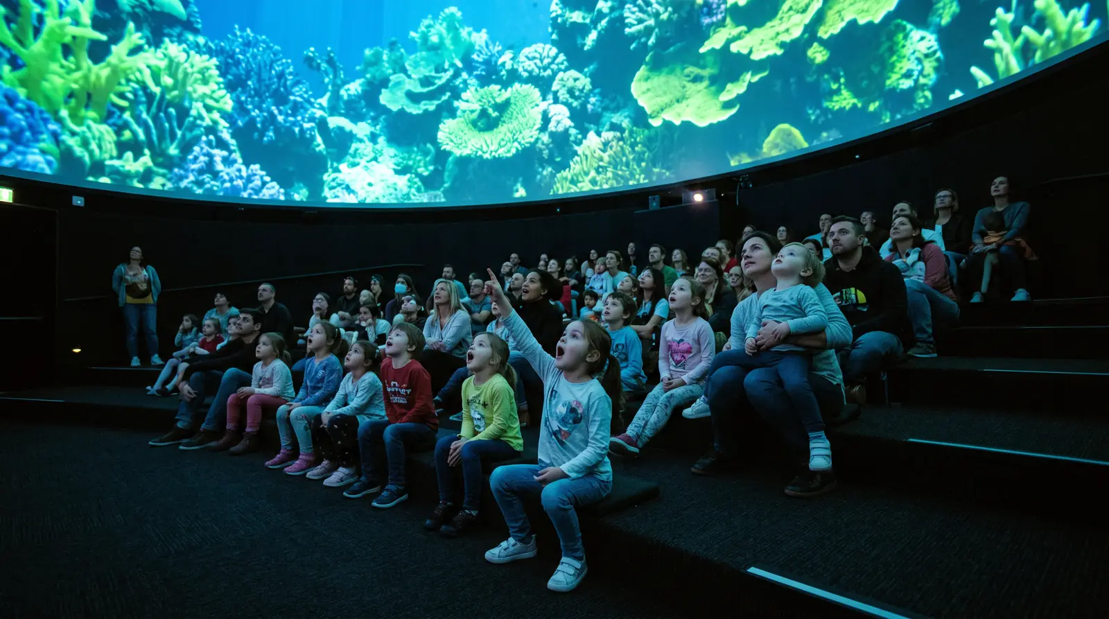 Families watching fulldome content inside an immersive projection dome