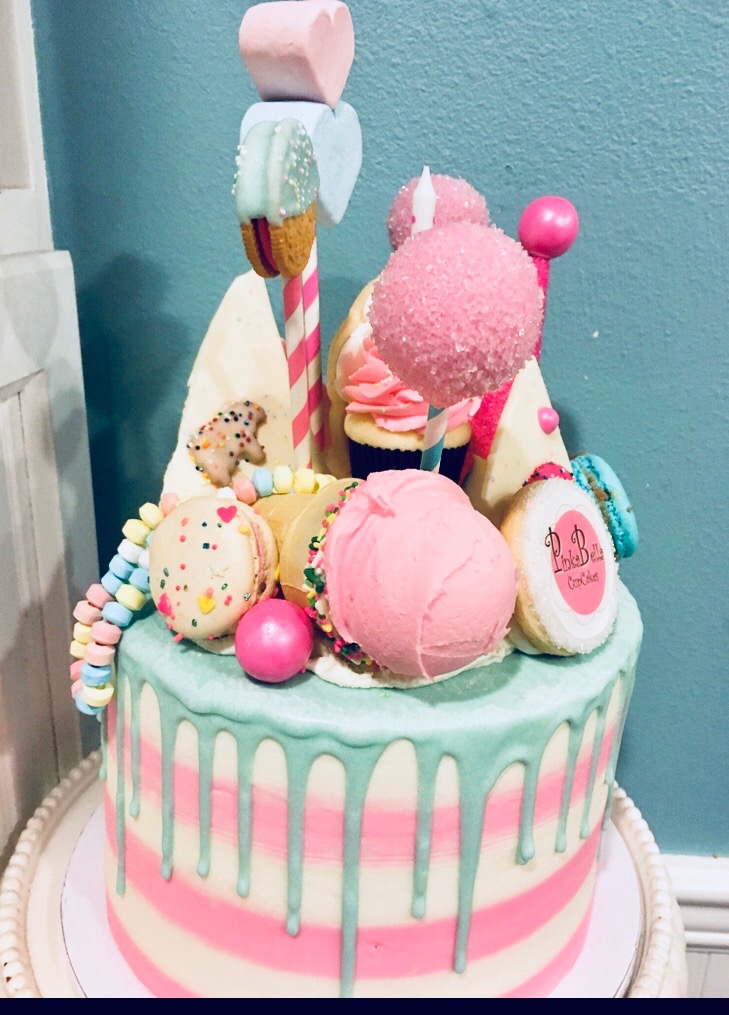 A decadent custom cake topped with all kinds of sweets