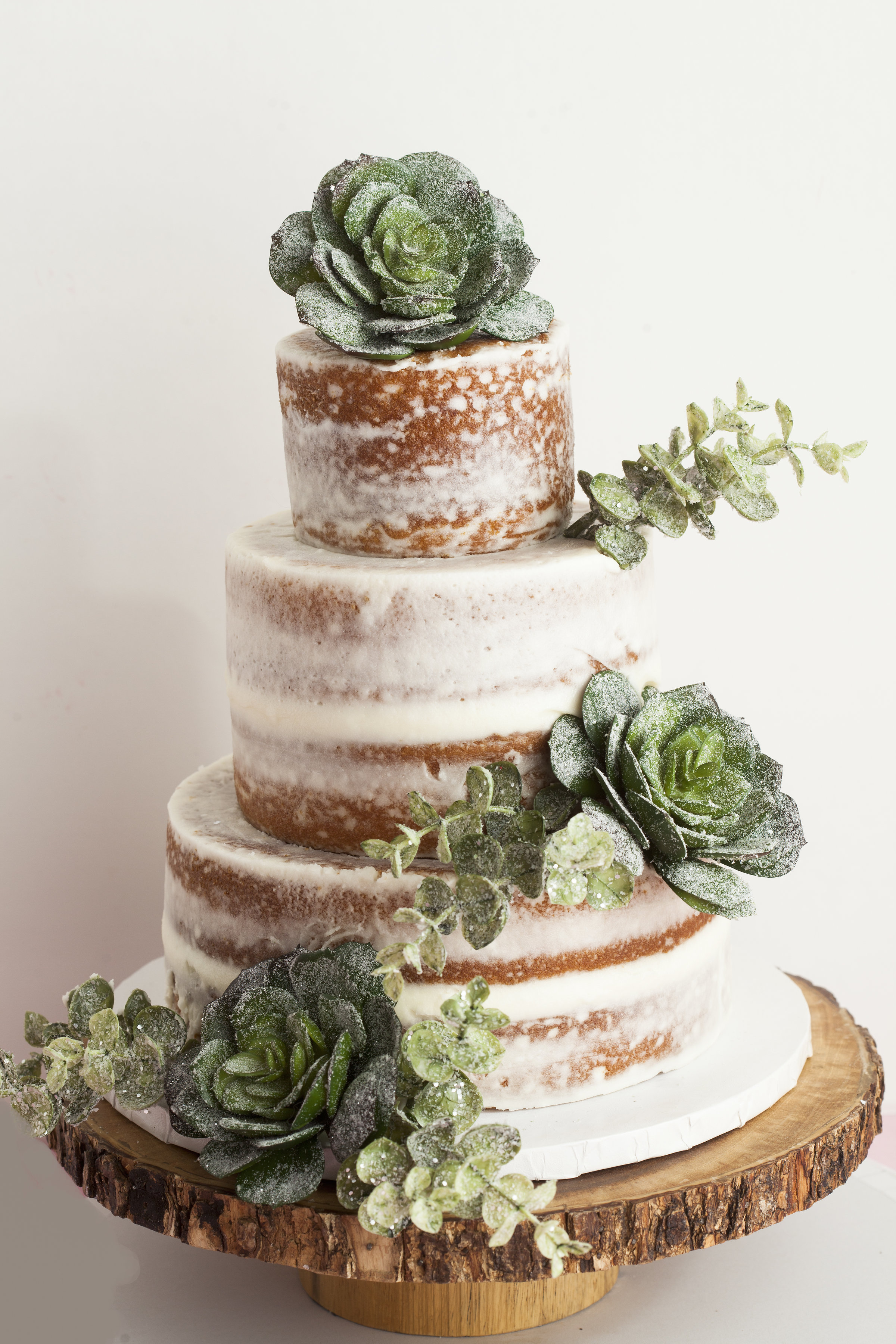 A rustic wedding cake by Pinkabella with greenery