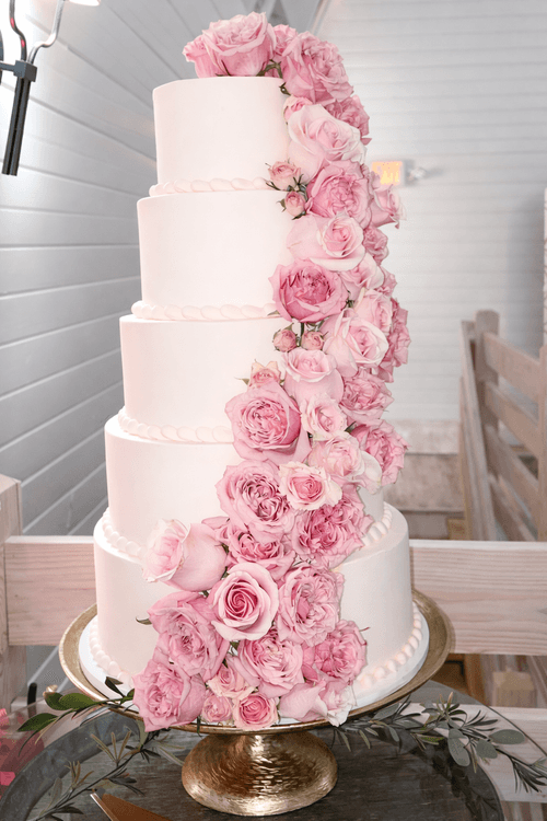 A 5 tier Pinkabella Wedding cake with pink roses cascading down