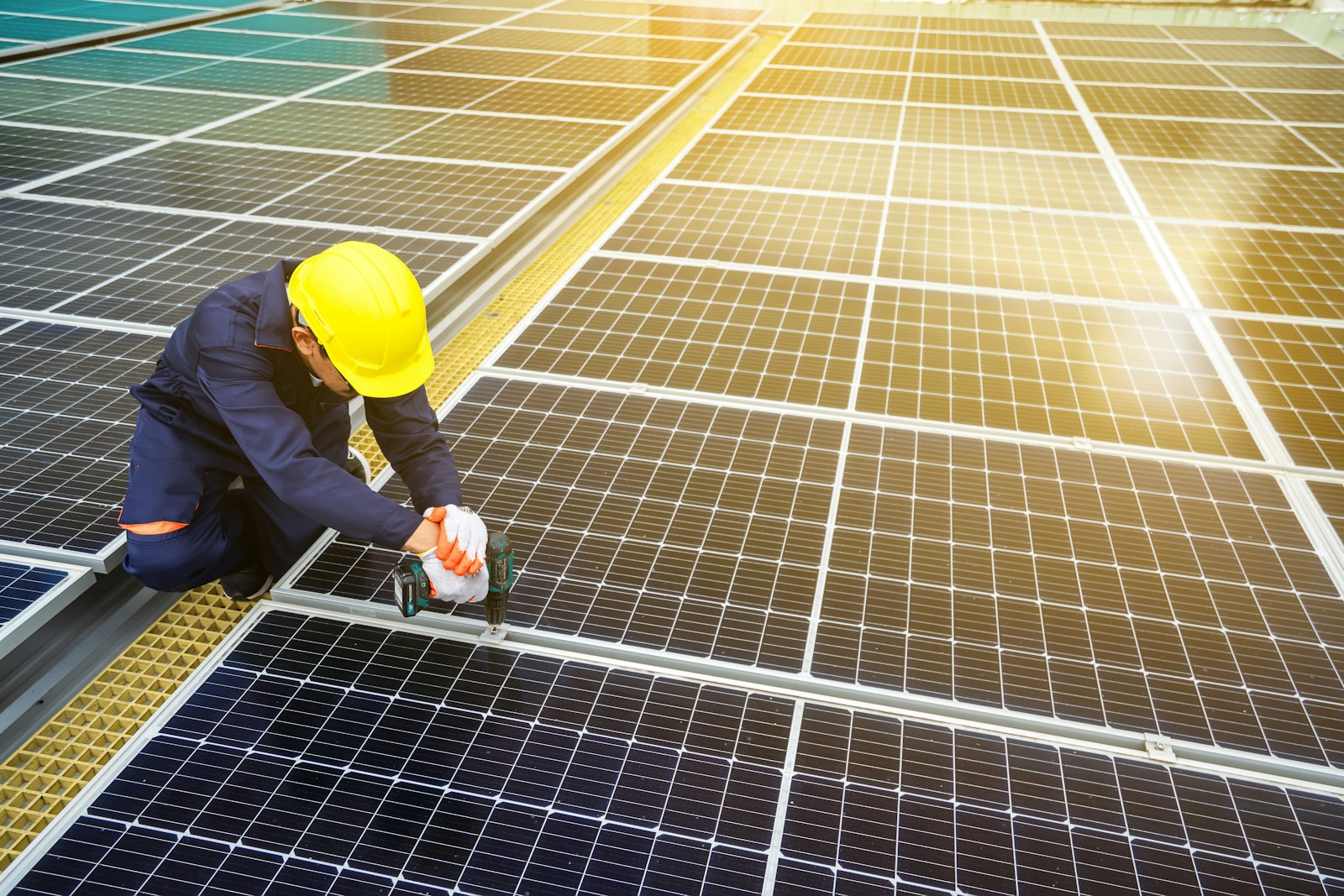 Installer in a hard hat working on a solar panel