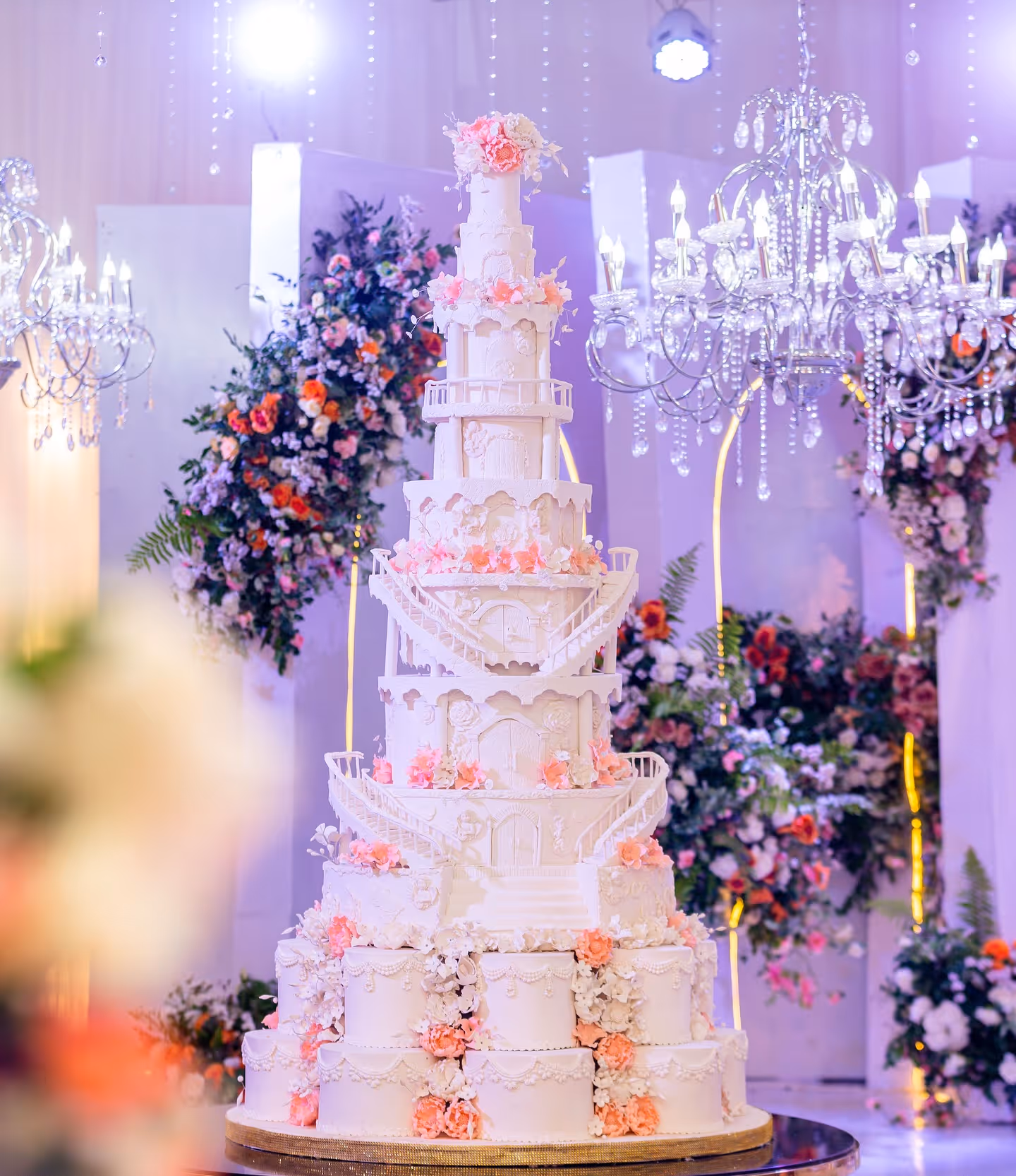 Wedding cake presentation using a drop-down chandelier feature during a celebration at a Cypress TX event venue.