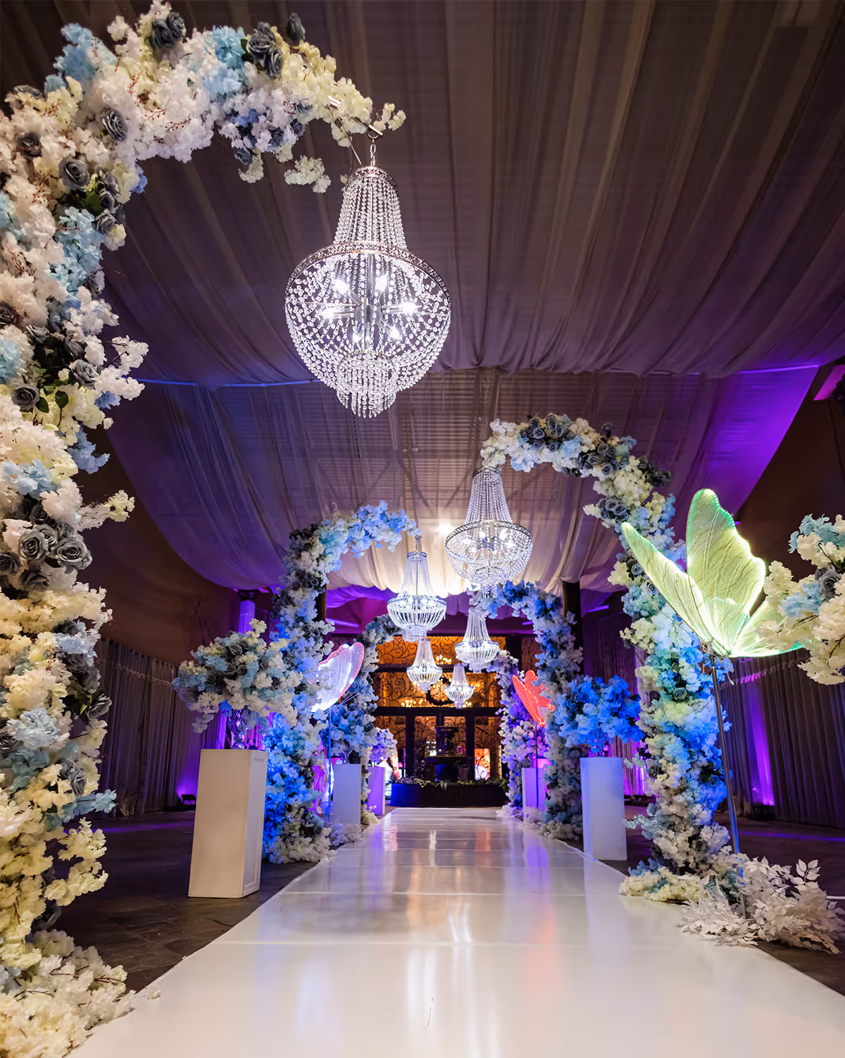 Ballroom interior with crystal chandeliers and uplighting setup for weddings and quinceañeras in Cypress TX.