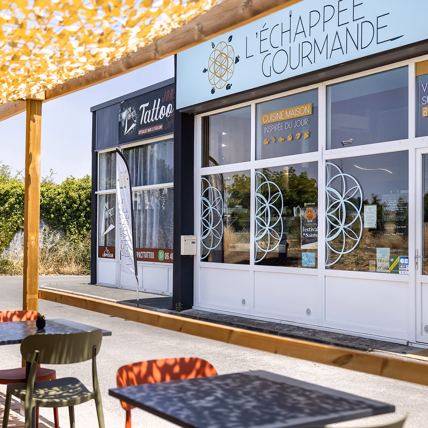 Façade du restaurant L'Échappée Gourmande, enseigne bleue « cuisine maison » et terrasse ombragée à l'avant