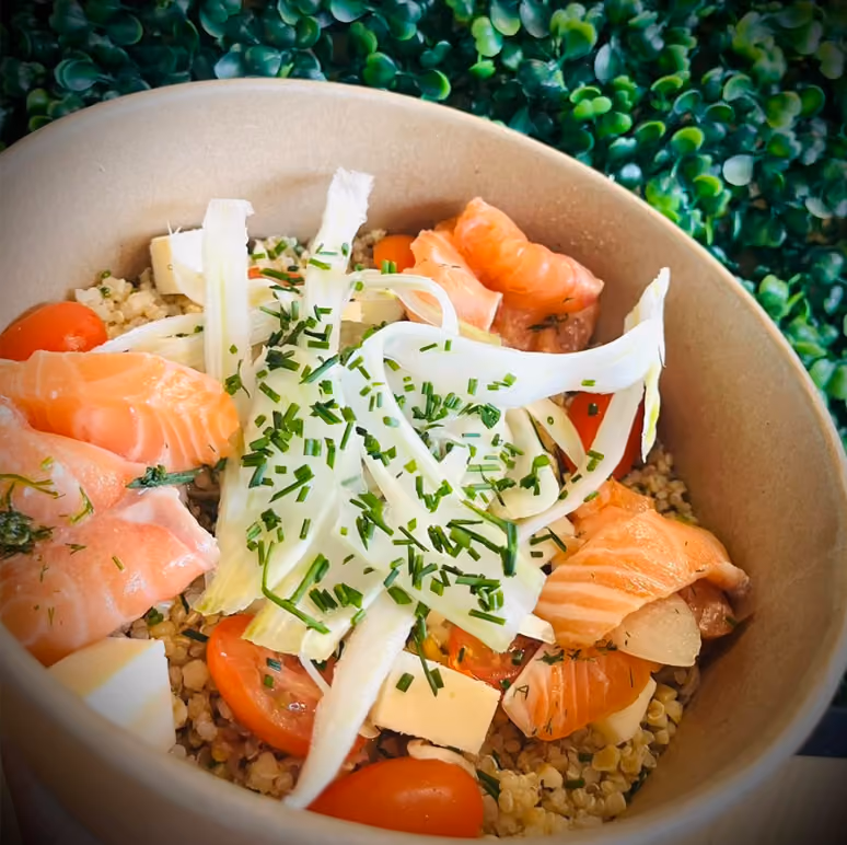 Bowl de quinoa au saumon fumé, tomates cerises, fenouil émincé et ciboulette dans un bol kraft