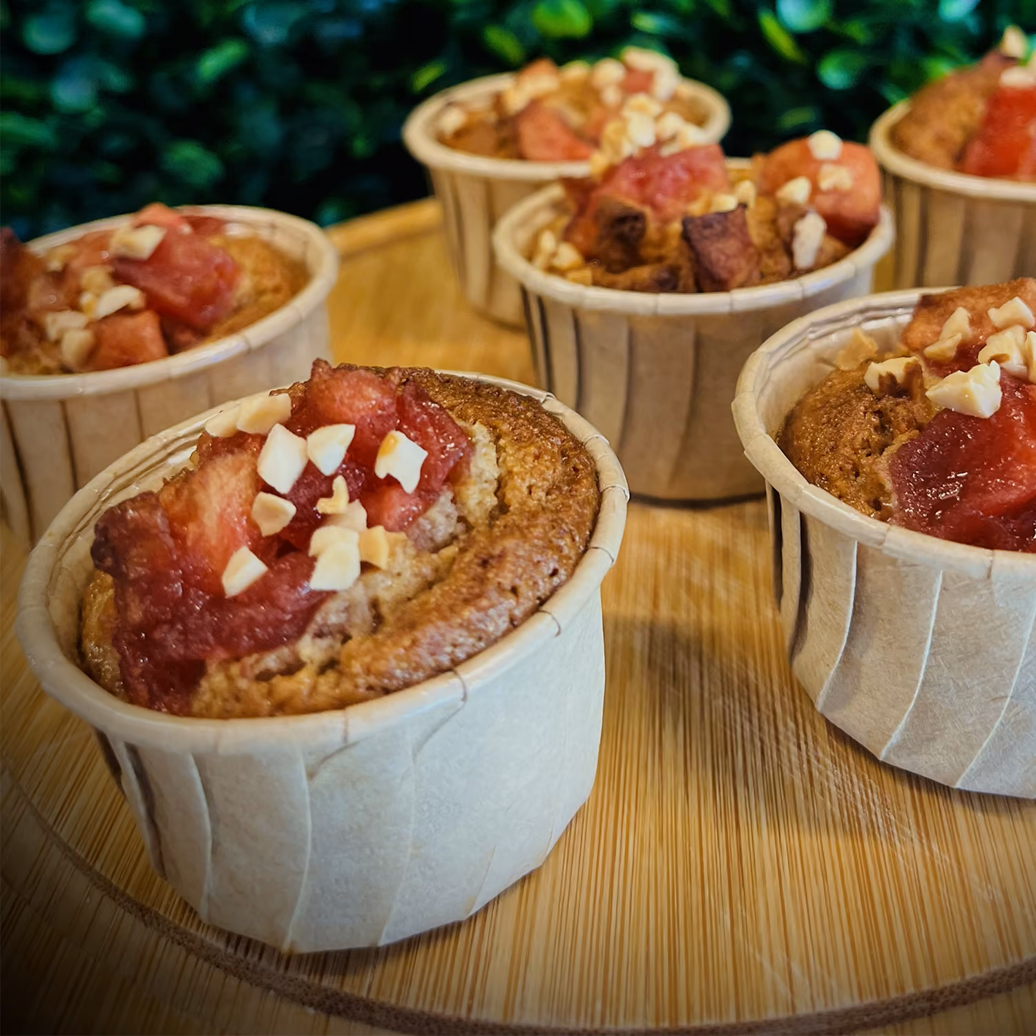 Muffins maison aux fruits rouges et éclats de noisette en caissettes bois, sur plateau en bambou