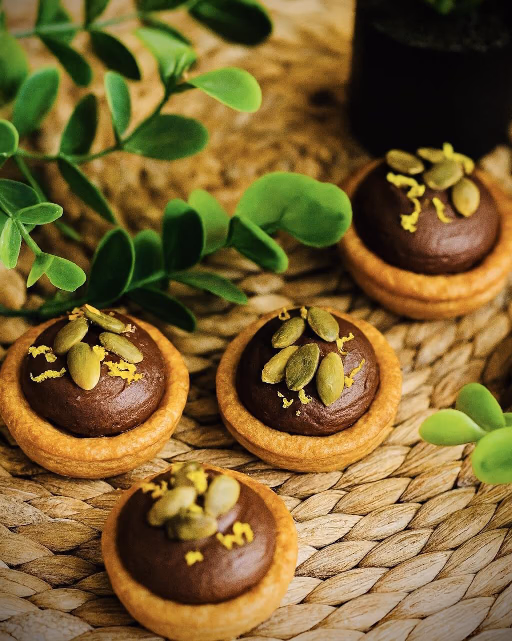 Tartelettes à la ganache chocolat, graines de courge et zeste de citron, sur set en fibres naturelles