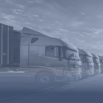 Mehrere geparkte moderne Lastwagen unter einem bewölkten Himmel.