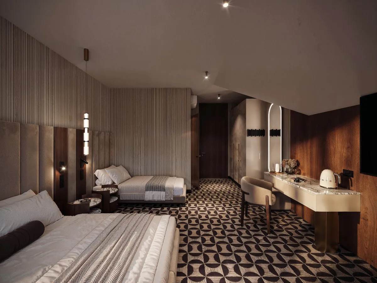 Nowoczesny pokój hotelowy z dwoma podwójnymi łóżkami, wzorzystą podłogą i toaletką z krzesłem oraz czajnikiem elektrycznym.