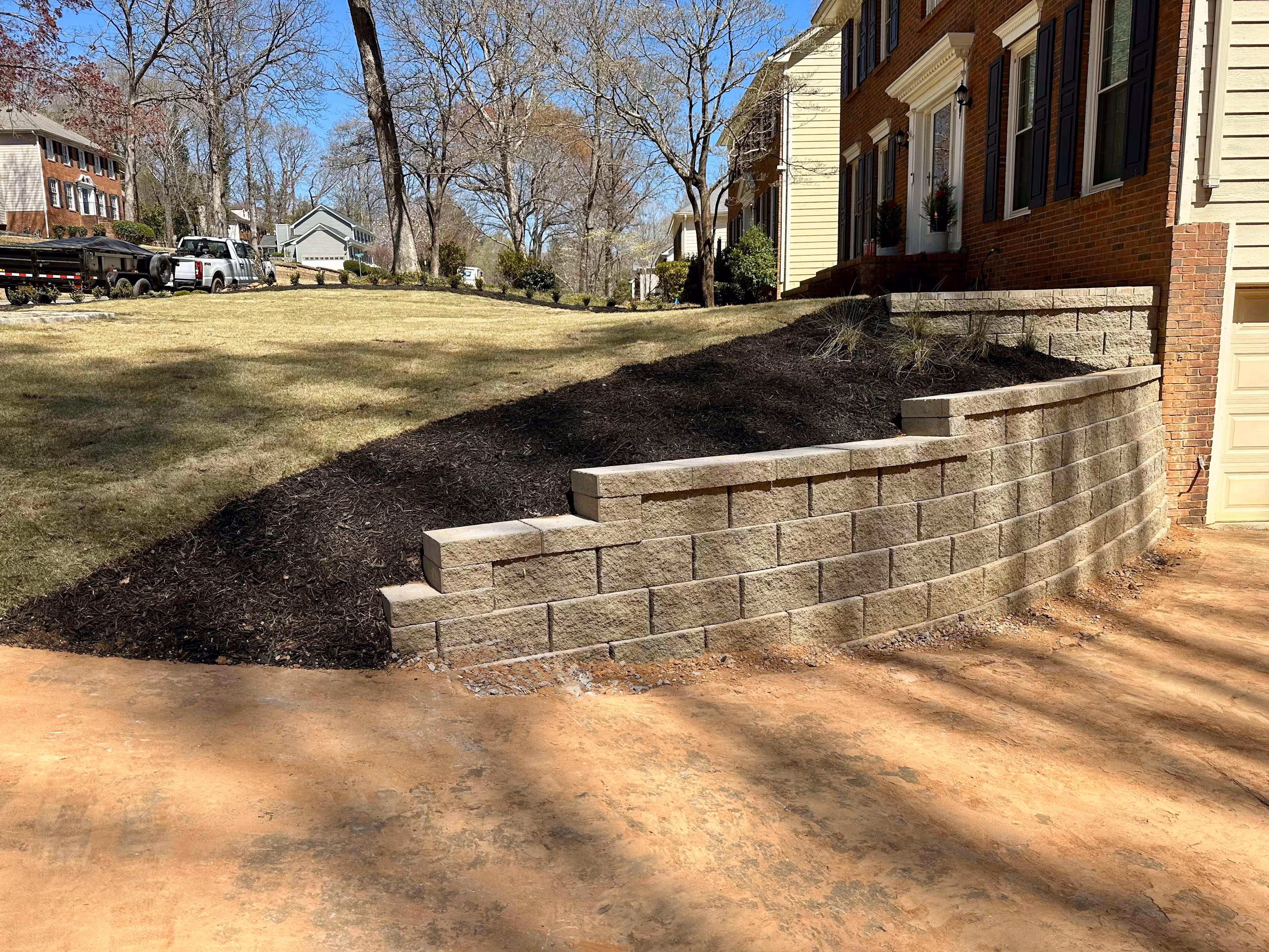 retaining wall on side of driveway with front yard and home in background