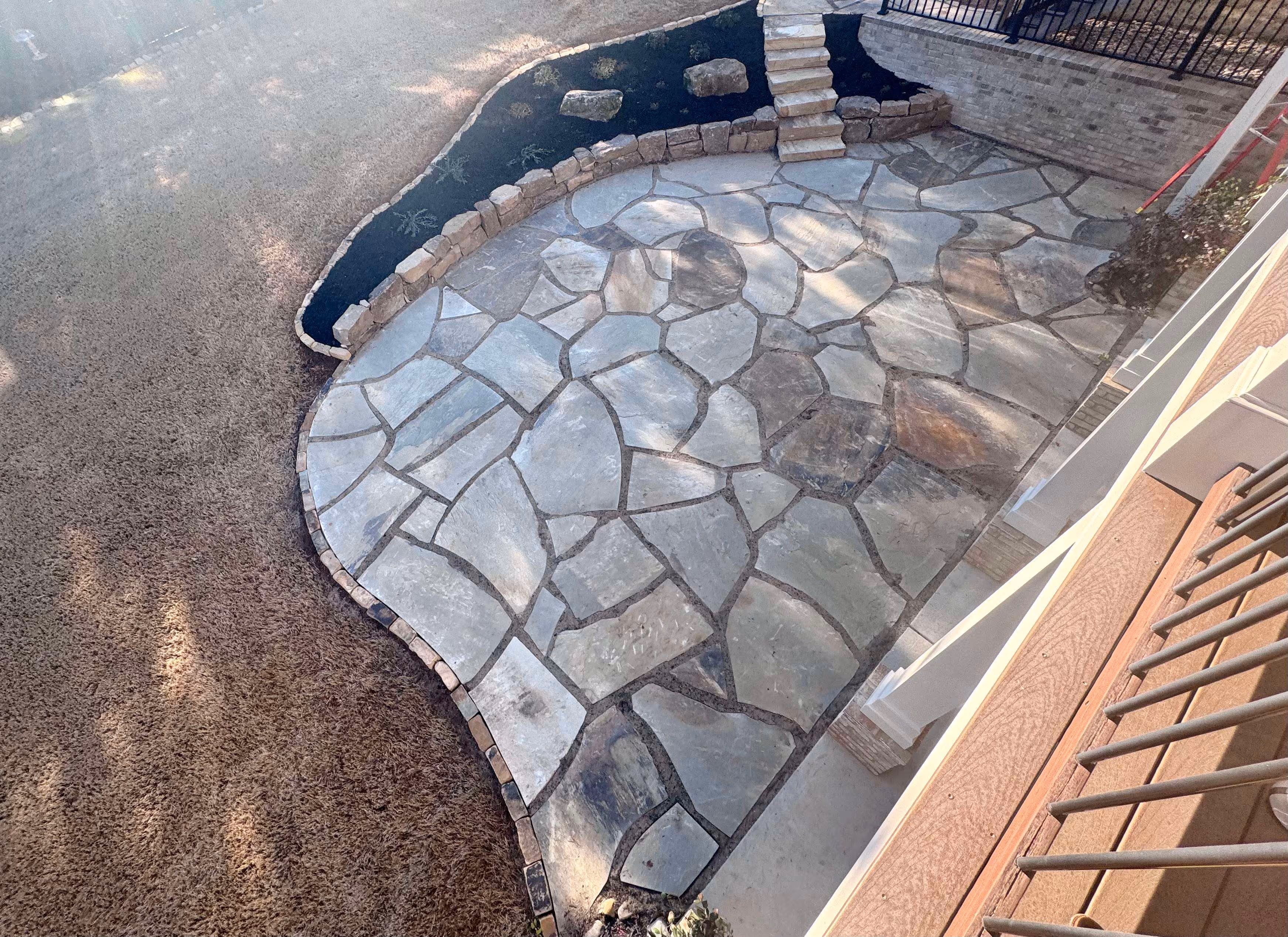 overhead view of flagstone patio and boulder wall