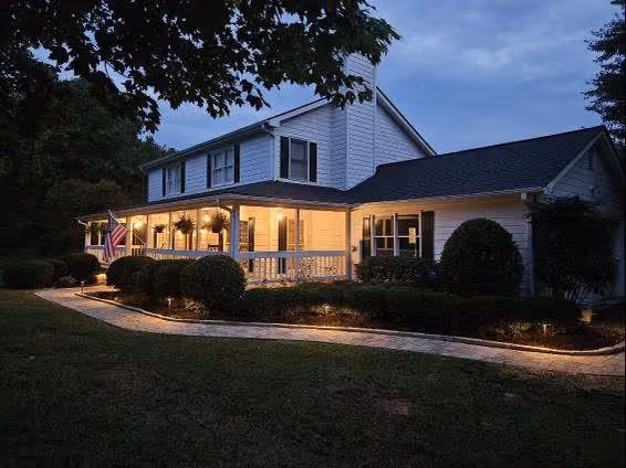 white home and front yard well lit by home lighting