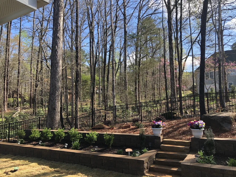 multi level modular retaining wall with staircase between the middle and plants between levels