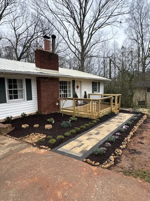 paver patio from driveway to front porch of home with plants and mulch to the side