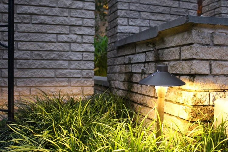 ambient lighting coming from outdoor light in front of grass and brick facade
