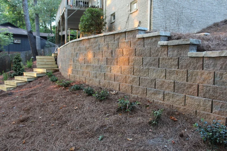 modular retaining wall with pine straw and greenery below