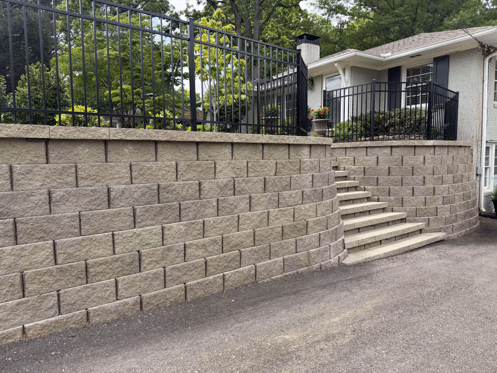 modular retaining wall with staircase in center in front of home