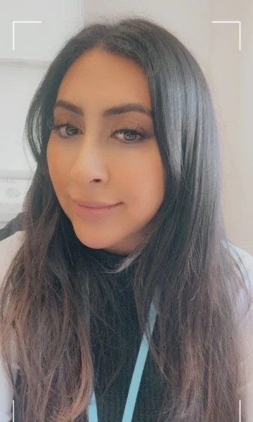 Portrait of Neelam, a woman with long dark hair.
