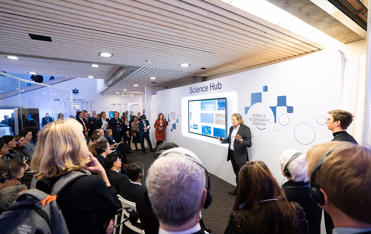 Speaker presenting data on screen to an audience at the Science Hub during the World Economic Forum.