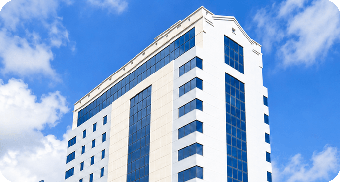 Edificio moderno de oficinas con ventanas de vidrio bajo un cielo azul claro.