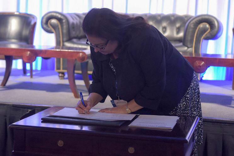 The Comptroller of Puerto Rico, signing the agreement.