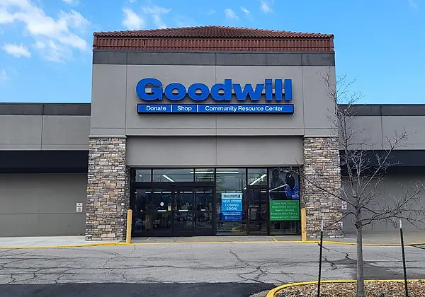 Exterior of Goodwill store with large blue sign and stone accents on front facade under a clear sky.